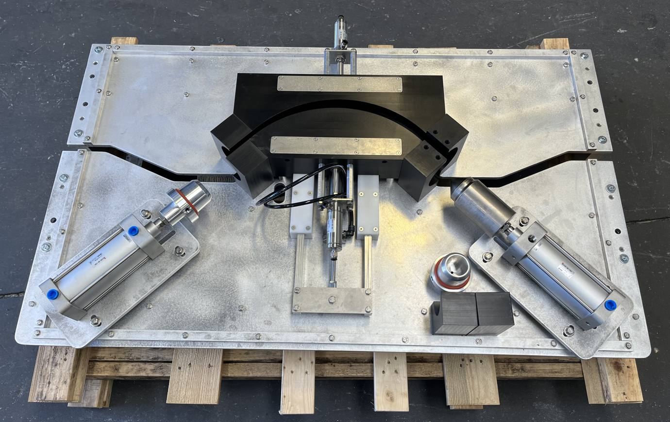 Pneumatic bending fixture with a curved form on an aluminum plate