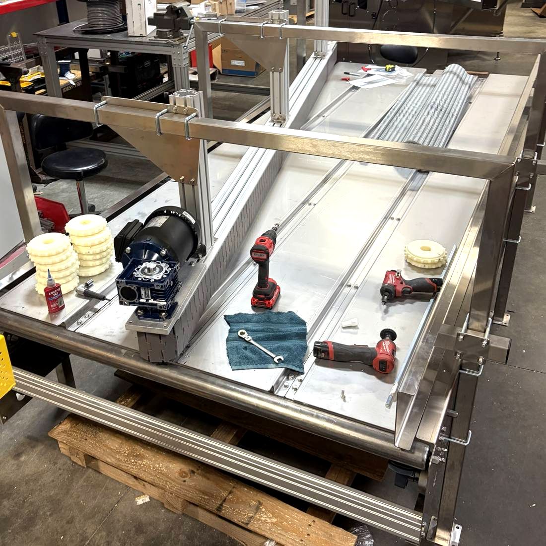 The same combining conveyor being assembled in the shop, with motor, sprockets and tools on the bed