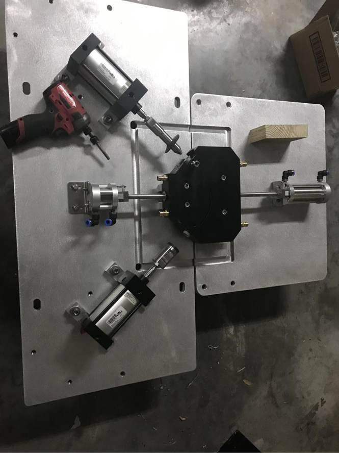 Pneumatic cylinders around a black fixture block