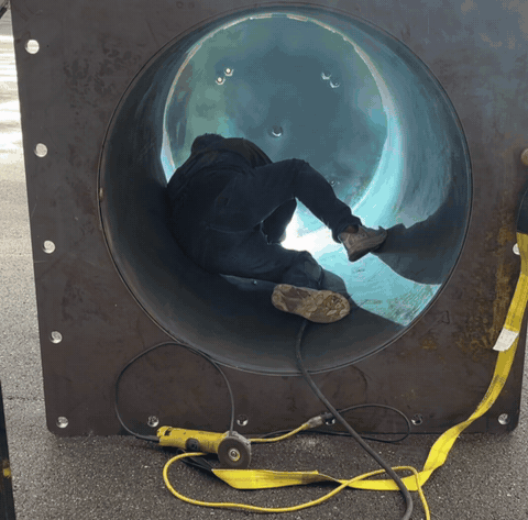 Welder working inside a large riser tube