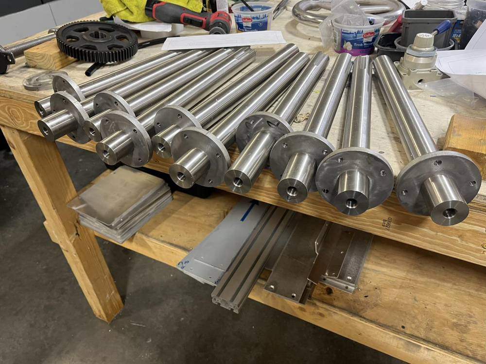 Machined stainless shafts on a workbench