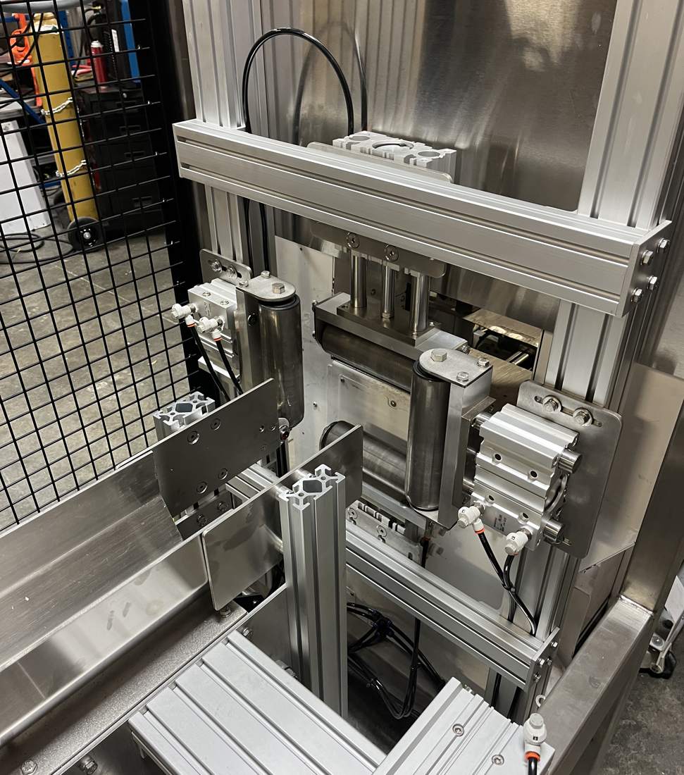 Stainless machine with rollers and pneumatic cylinders on an aluminum frame