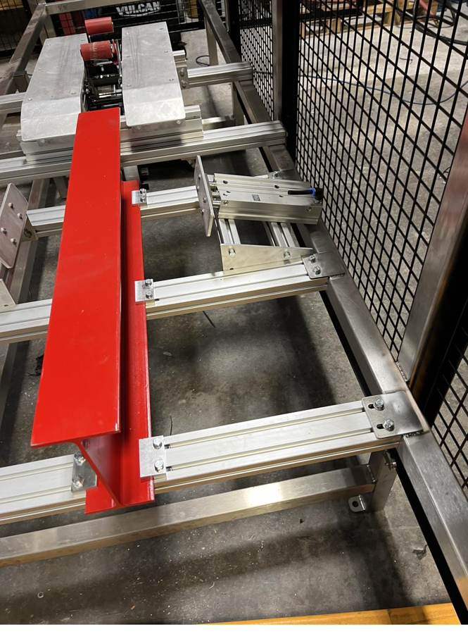Red carriage on linear guides inside a frame